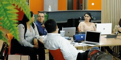 Na imagem, funcionários conversam na Mango Tree, o melhor coworking de São Paulo